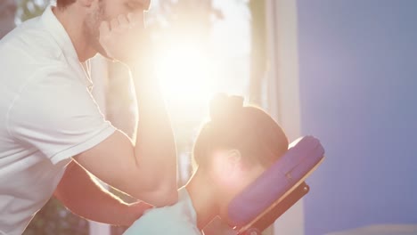 Male-physiotherapist-giving-back-massage-to-female-patient