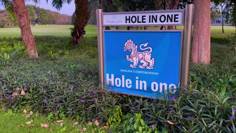 lush green fairway with 'hole in one' sign