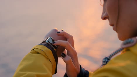 woman checking smartwatch at sunset