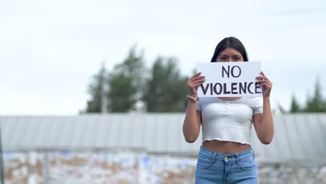 latin american woman holding no violence sign, protest against war in ecuador