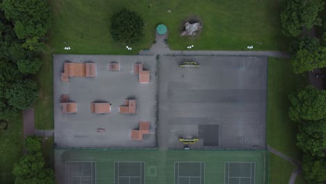 Suburban-public-playground-flying-above-tennis-court-top-down-aerial-view-reverse-lowering