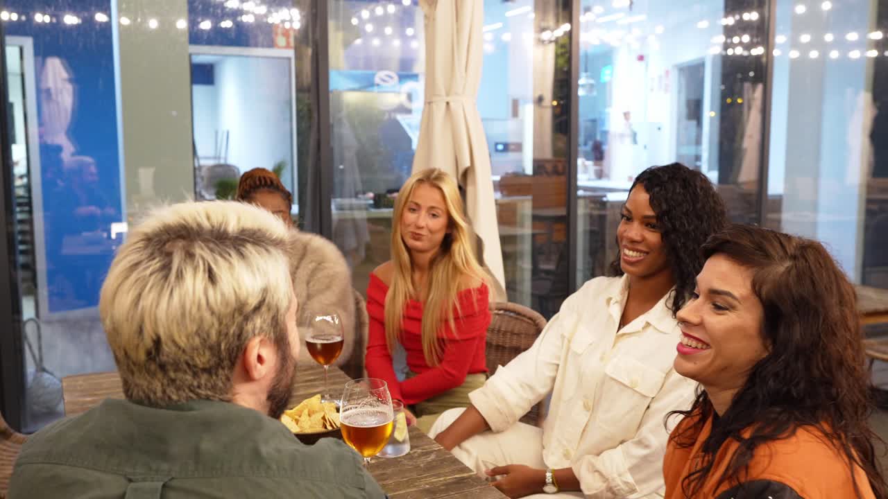 People gathering around a table at an outdoor restaurant