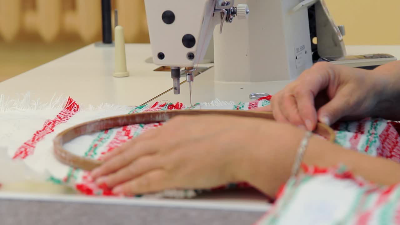 Closeup female worker working with sewing machine. Woman weaver working