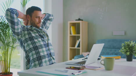 relaxed man looking at laptop