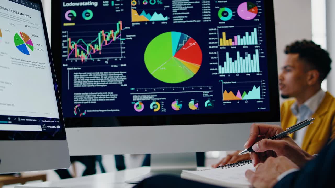 Close-up angle of a computer screen displaying colorful financial graphs in a modern office