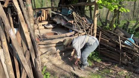 a woman try to break wood stick tree dry branches to make fire in a clay old traditional ground oven in a rural village to make flat persian bread lavash in iran kneading dough and fermentation bakery