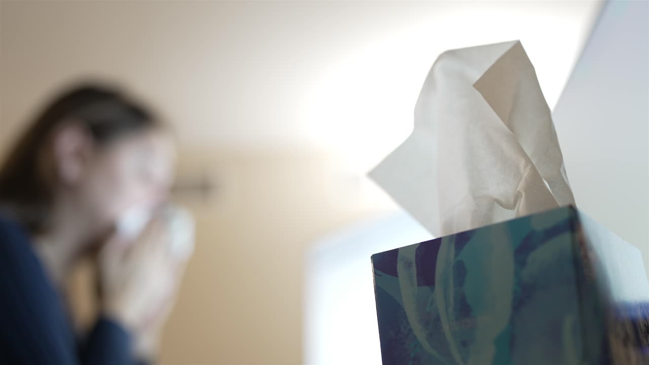 Close up hand extracting tissue from the dispenser, office hygiene.