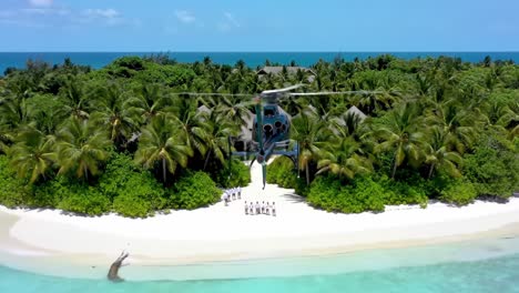 aerial view of a helicopter approaching a tropical island resort surrounded by lush palm trees and crystal clear waters