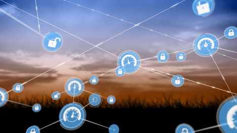 animation of network of digital icons against landscape with grassland against sunset sky