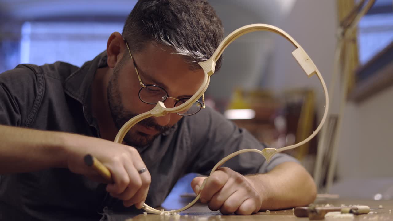 luthier creando costillas de violín en el taller