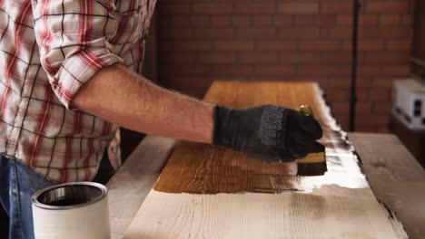 man staining a wooden table top