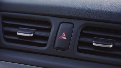 presionando a mano el botón de las luces de peligro del coche