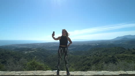 toma aérea de una mujer vestida de gimnasio blogueando en video sobre la fantástica naturaleza en marbella, españa