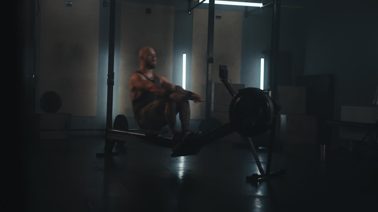 мужчина работает на гребной машине в тренажерном зале