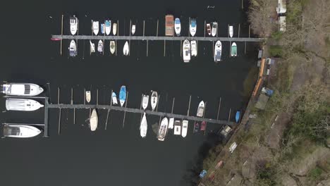 aerial view of a small boat dock with a few vessels anchored, capturing calm waters and minimal waterfront scenery.