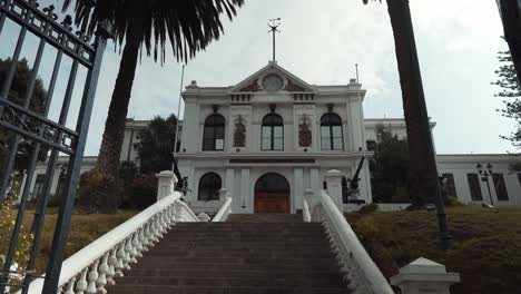 Tilt-down-revealing-National-Maritime-Museum-facade-building-in-Cerro-Artilleria-on-an-overcast-day,-Valparaiso,-Chile