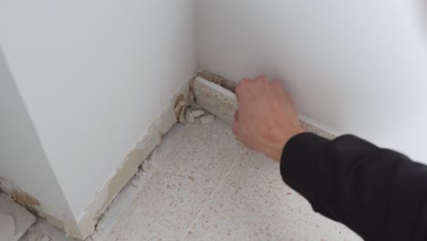 hand of caucasian man scraping construction waste from floor