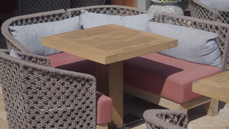 outdoor cafe seating area with woven chairs and wooden tables