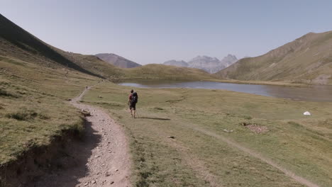 young man walking in the mountains on a sunny day in french pyrenees close to a lake