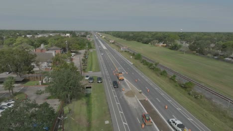 a 4k aerial view of a compact track loader moving material at a road construction site on highway 3 in houston, texas.