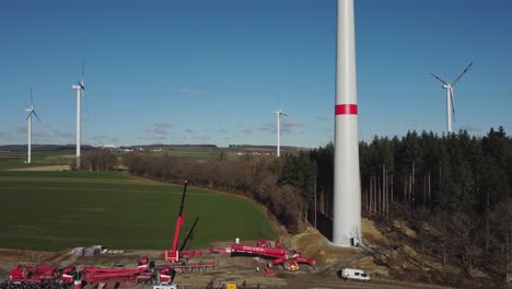 aerial view of wind turbine farm under construction - drone ascending