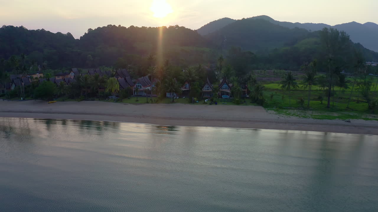Bungalow cottages on calm beach in Koh Chang at dawning sunrise