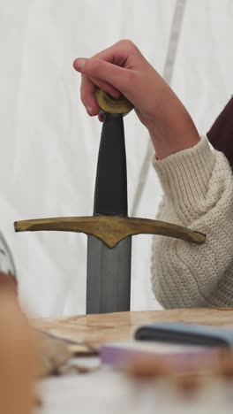 female knight talks to witch sitting at table. warrior holds sword and waits for magical drink to be prepared to replenish physical strength and fearlessness