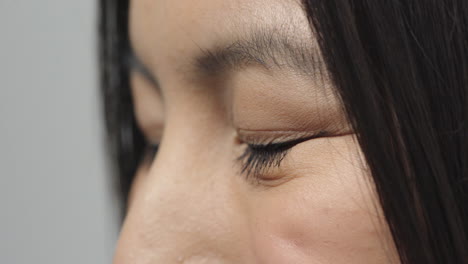 close up asian woman eyes smiling cheerful looking at camera side view