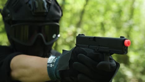 tipo del ejército mirando hacia abajo con la mira de su pistola y disparando al objetivo