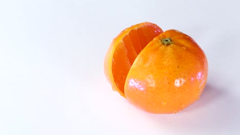cuchillo muy afilado cortando una rodaja de mandarina en superficie blanca