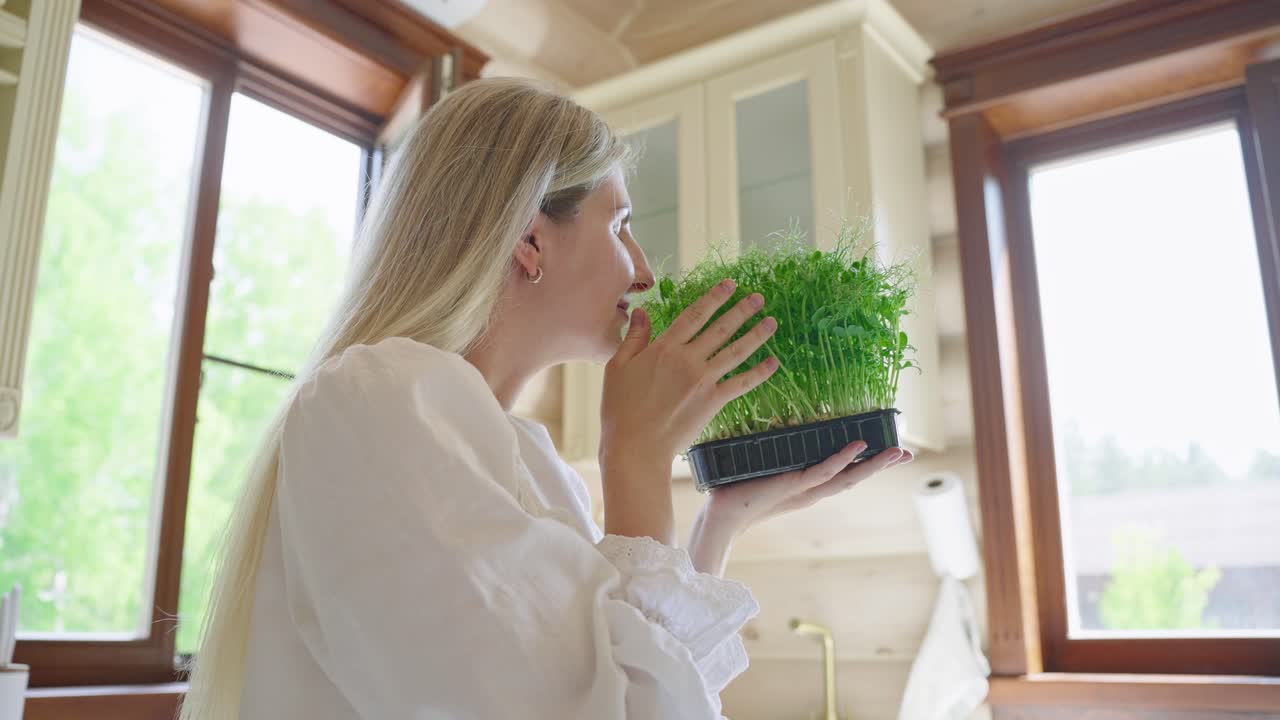 Woman caring for microgreens in a kitchen