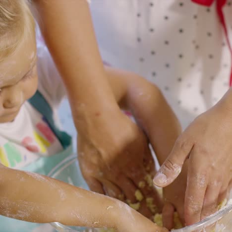 Little-girl-helping-to-knead-the-pastry-dough