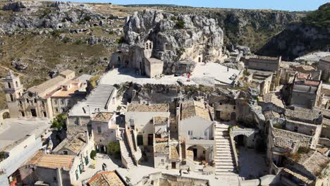 Aerial-drone-shot-headed-toward-a-huge-rock-in-Matera,-Italy