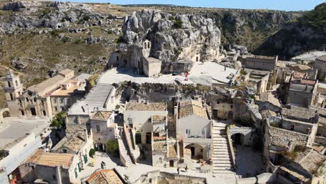 tiro aéreo de drones dirigido hacia una enorme roca en matera, italia