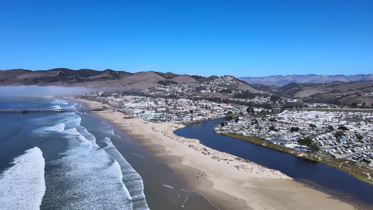 pismo 해변 위를 날아다니며, 놀라운 바다 전망과 뒷면의 웅장한 산을 포착합니다. 이 환상적인 항공 드론 영상으로