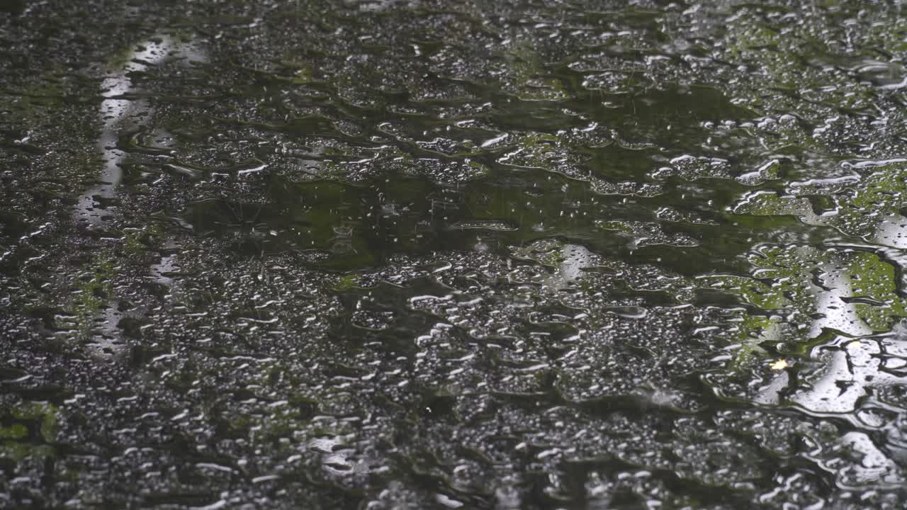 Rainfall on glass table top, very wet surface, slippery counter, raindrops