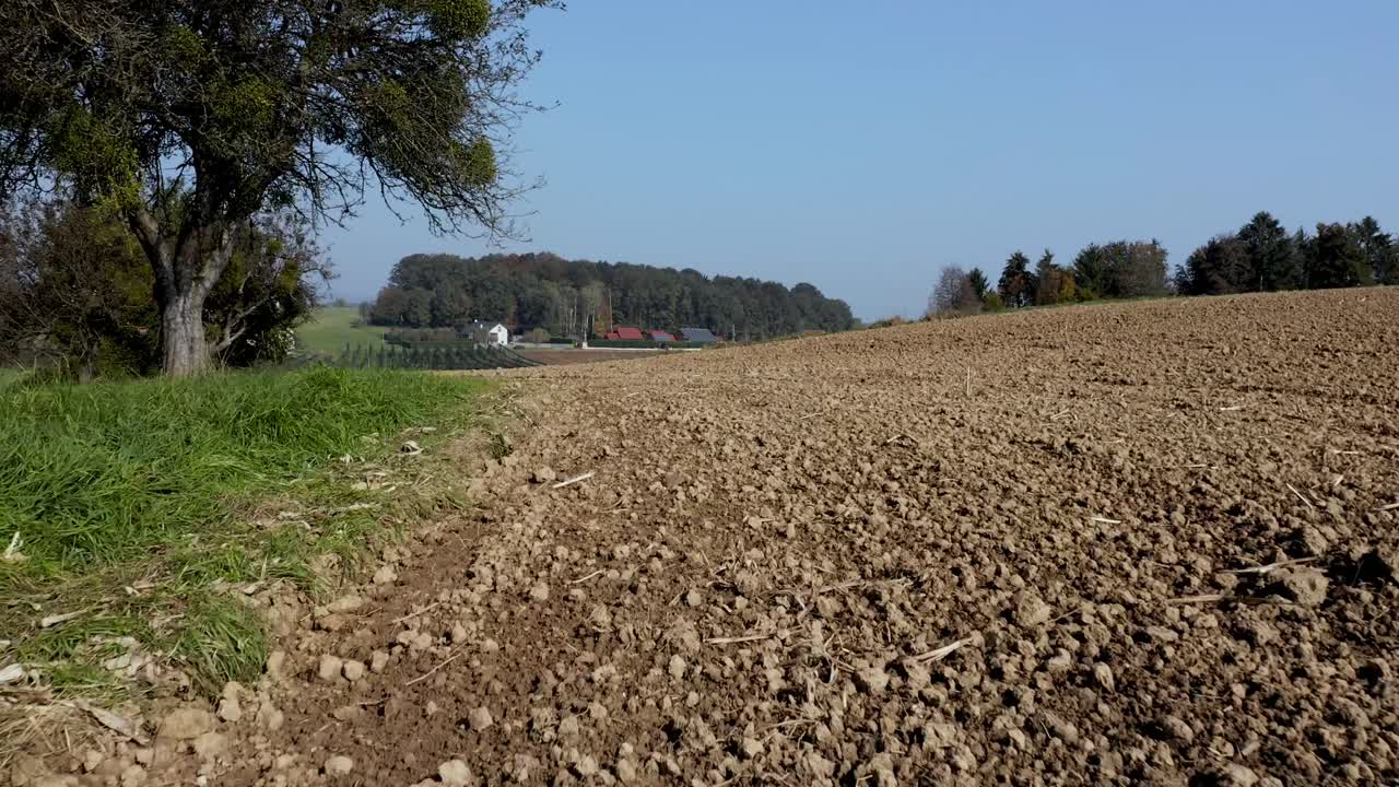 disparo de un dron volando cerca del suelo de un campo de cultivo en tierras de cultivo en el campo de eslovenia cerca del pueblo de cresnjevec