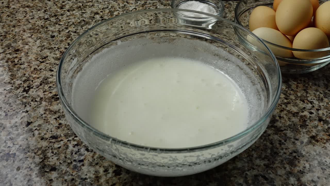 Beating of protein and sugar the mixer in a bowl. Cream preparation. Time lapse