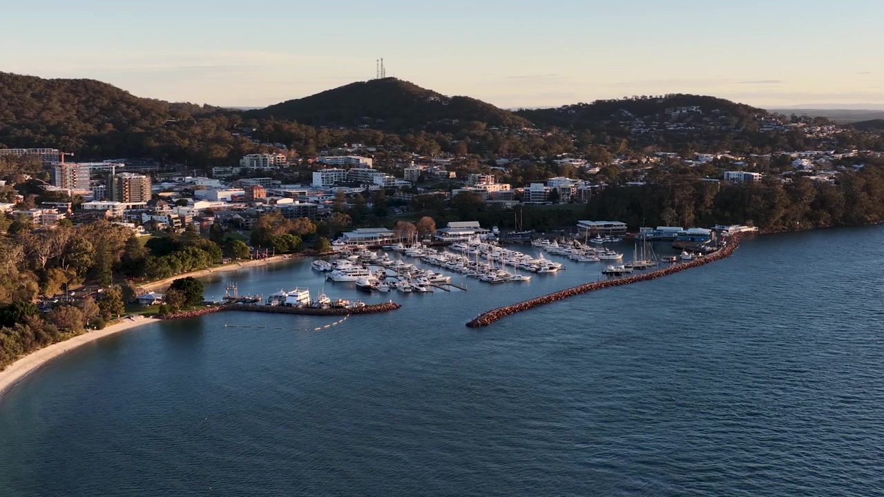 Ampia ripresa aerea di yacht nel porto turistico di Nelson Bay durante l'ora d'oro, Nuovo Galles del Sud.