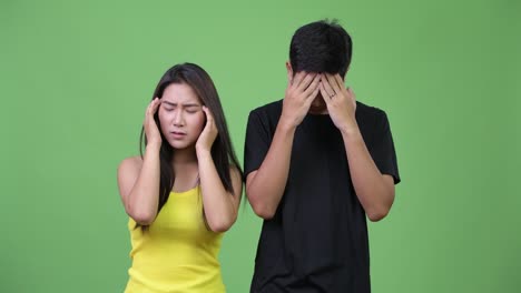 young asian couple having headache together