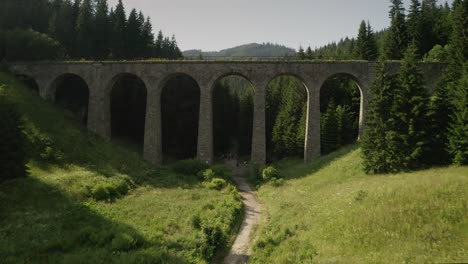 flying forward under the chmarocsky viaduct in slovakia and above a forest