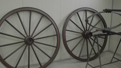 large old carriage wheels standing in a modern workshop