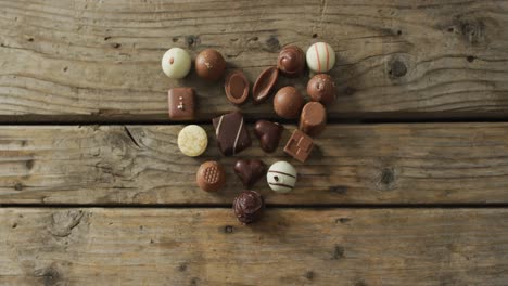 Heart-shape-black-and-white-chocolates-on-wooden-background-at-valentine's-day