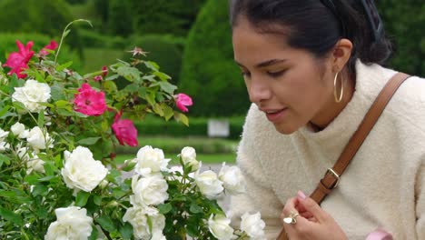 Young-attractive-woman-smells-rose-flowers,-portrait-view