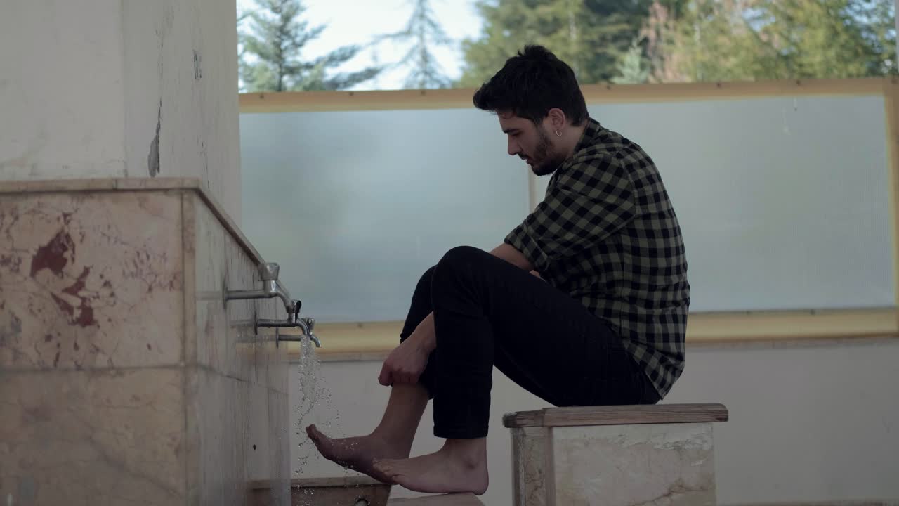 Young Muslim Man Taking Ablution For Prayer In The Mosque