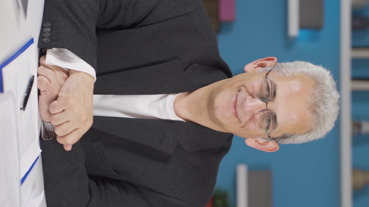 video vertical de un trabajador de oficina en casa expresando su mente y éxito a la cámara.