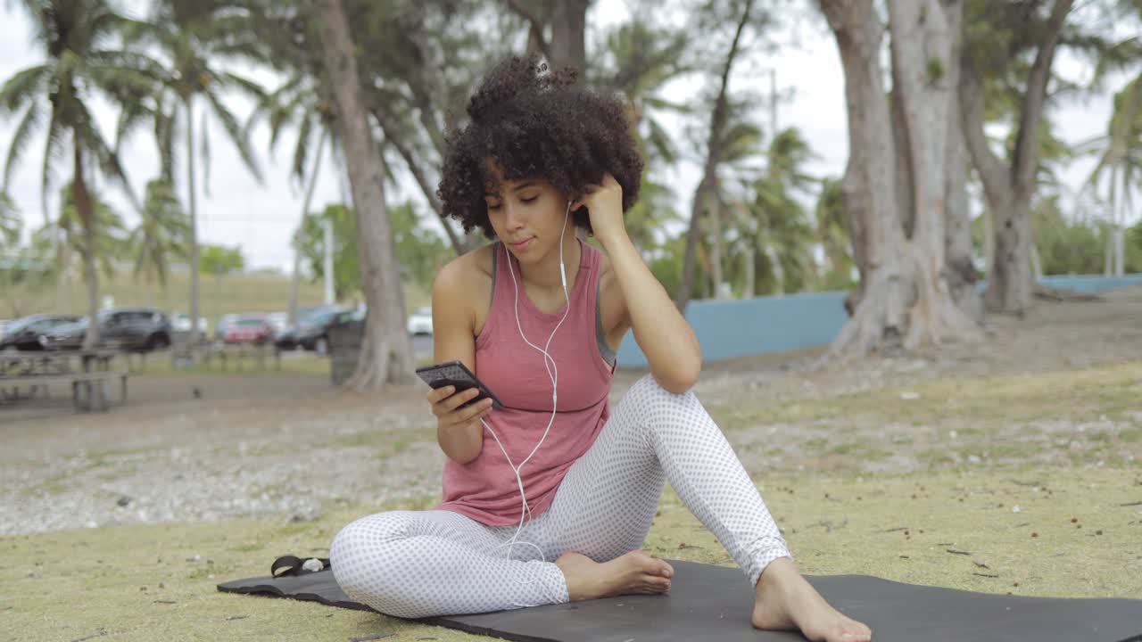 mujer escalofriante con teléfono en la alfombra en el parque