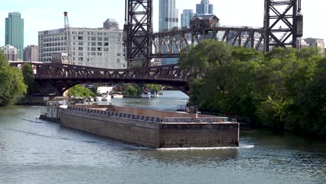 barge-sails-on-a-river-past-old-bridges-4k
