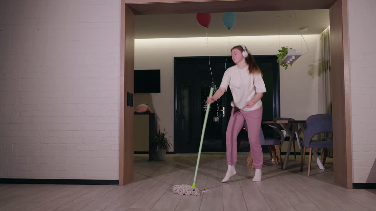 chica limpiando la casa y bailando
