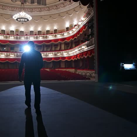 theater actor has rehearsal before performance. dark light behind scene. man in formal clothes with handfree microphone. classic theater concept